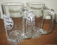 Two clear glass beer mugs side view showing handles and bases