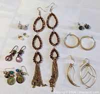 All eight pairs of earrings arranged on cloth background