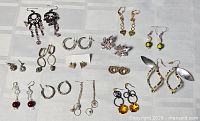 Entire grouping of assorted earrings laid out on cloth