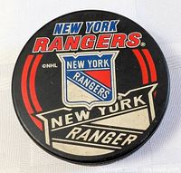 Top view of puck showing full New York Rangers logo and graphics