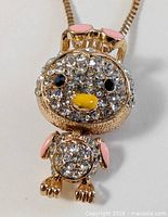 Close-up of penguin pendant showing rhinestones and enamel details