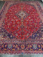 Full view of rug showing red field and navy border