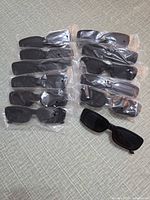 overview of eleven packaged sunglasses plus one unwrapped pair