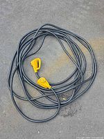 Coiled black RV extension cord with yellow ends