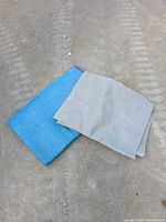 Grey mat folded over blue pad on pavement
