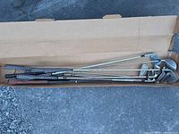 Top view of open box showing all nine golf clubs