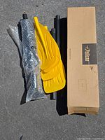 Carrier tubes, two yellow paddles, bubble-wrapped hardware and Pelican box displayed on ground