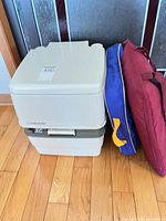 Toilet stacked, blue bag and red bag standing