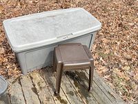 Outdoor storage box and small plastic table on wooden deck