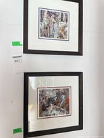 Both framed prints hung vertically on wall