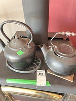 Both cast iron kettles side by side on stove surface