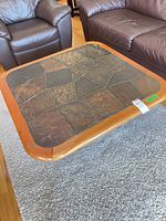 Top view of square coffee table showing wood frame and multicolour slate tile surface