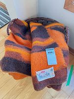 Blanket draped over basket showing colors and attached label