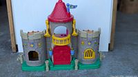 Front view of Fisher-Price Little People Castle showing towers, balcony, drawbridge and flag