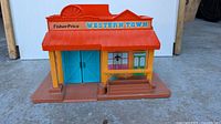 Front view showing Fisher-Price Western Town facade, porch and doors