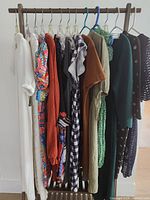 Full rack of eleven dresses on wooden stand