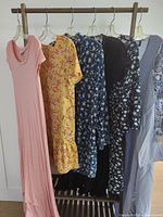 Front view of all six dresses hanging on rack