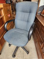 Front angled view of entire chair showing upholstery, armrests and wheeled base