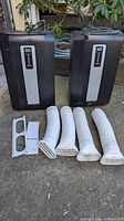 Two Haier portable AC units with hoses and window kit on ground