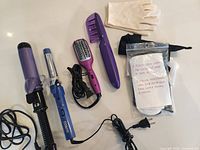 Group shot of all curling irons, brush, comb, gloves, and accessories