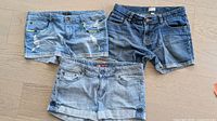 Three pairs of denim shorts laid flat