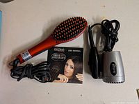 Both hair appliances, cords, and user manual visible