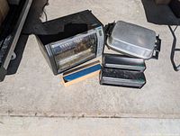 Group shot of toaster oven, electric skillet with lid, two EzeWrap dispensers, wooden dispenser