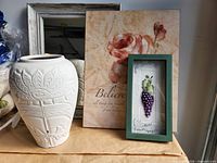 Mirror, canvas art, shadow box, ceramic vase grouped on tabletop