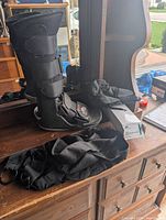 Walking boot, arm sling and boxed ankle brace on dresser