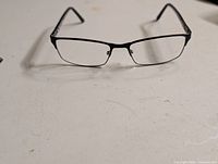 Front view of black rectangular metal eyeglass frame