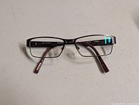 Front view of Ted Baker rectangular eyeglass frame showing prescription lenses and burgundy temples