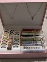Watch kit box open showing necklaces, watch, bezels, straps