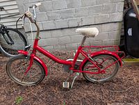 Left side view of red Halfords children's bicycle showing frame, wheels and components
