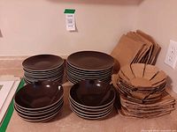 Stacks of dinner plates, lunch plates, bowls, and packaging material