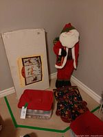 Boxed three-panel fireplace screen beside Santa figure and ornament bin