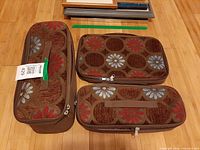 Three brown canvas floral padded zip bags