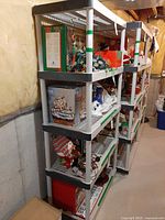 Full view of beige five-shelf plastic resin rack loaded with contents (contents excluded)