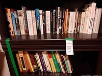 Two shelves of assorted paperback books