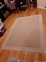 Full view of rectangular woven area rug on hardwood floor