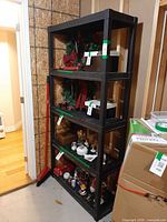 Full view of 5-shelf Rimax black plastic rack with contents shown for scale