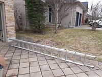 Full view of the aluminum extension ladder collapsed on patio