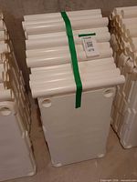 Stacked white plastic shelf panels and posts strapped together