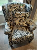 Front view of wingback chair with pillow showing pattern and condition