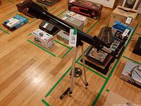 Full view of telescope on tripod with accessory on floor