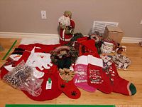 overview of lot showing stockings, Santa cookie jar, teddy bear wreath, Santa figurine, garland, pinecones