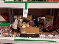 Shelf with skates, teddy bear, boxes of decorations, toy truck, framed art