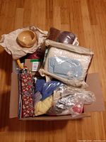 Overview of box with yarn bowl, textiles, tools and yarns