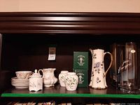 Shelf view showing all porcelain items, pitcher and boxed vase