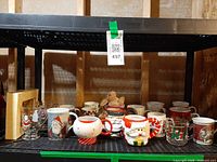 Full shelf of assorted mugs and plush bunny