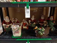 Full shelf view showing seven Santa figurines, ornament tub and sleigh
